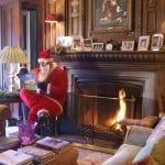 Santa reads in front of the fire